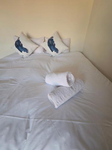 a bed with two towels and pillows on it at Mafjoint10 in eMalahleni