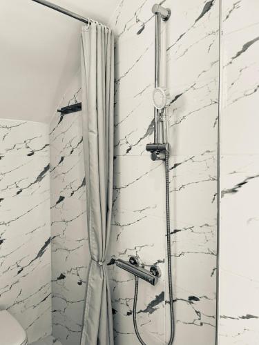 a shower with a shower curtain in a bathroom at La Perle de Bizerte in Banzart