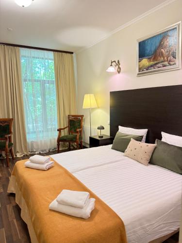 a bedroom with a large bed with towels on it at Alex Hotel in Odesa