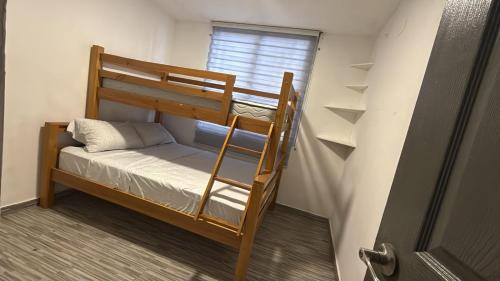 a bunk bed in a small room with a window at Arisbeth V in Panama City