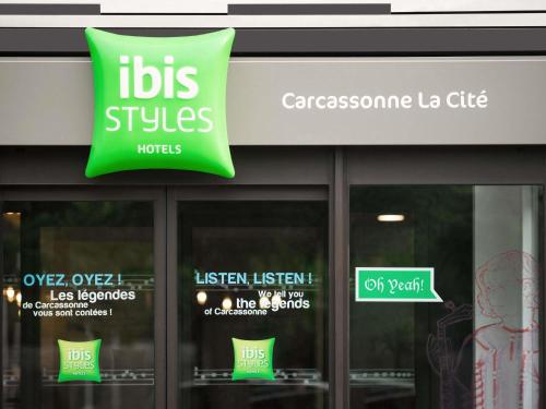 a store front with a green sign on the window at ibis Styles Carcassonne La Cité in Carcassonne