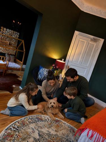 a group of people sitting on the floor with a dog at Sleephotels Alsterroom in Hamburg