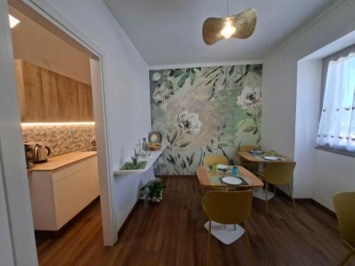 a dining room with a table and a kitchen with a painting at G&G Bed&Breakfast in Bonorva