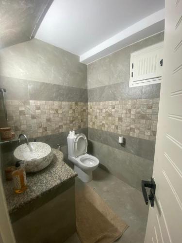 a bathroom with a toilet and a sink at Menzel à Midoun in Al Maqārisah