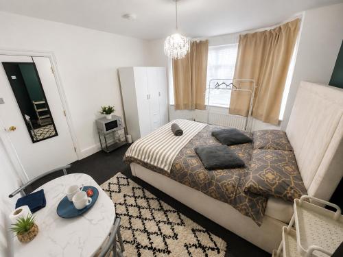 a bedroom with a large bed and a table at Lindi Property Cosy Double Room in Wyken