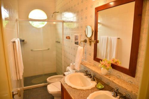 a bathroom with a sink and a toilet and a mirror at Hotel fazenda do Cedro in Areal