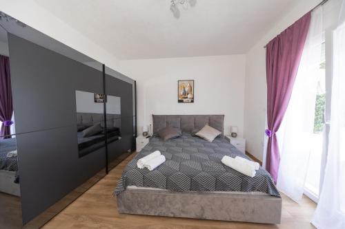 a bedroom with a large bed with purple curtains at Ilma Apartment in Trogir