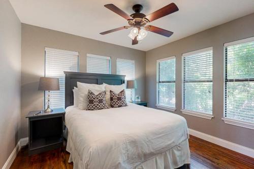 a bedroom with a bed with a ceiling fan at Spacious Lakefront Hideaway with Decks, Grill, Billiards, Tennis & Pool in Spicewood