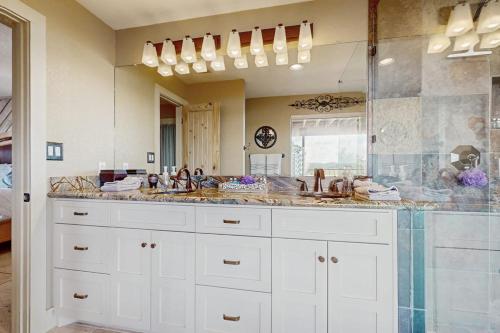 a bathroom with two sinks and a large mirror at Refined Panoramic Paradise on Lake Travis with Boat Launch and Tesla Charger in Spicewood
