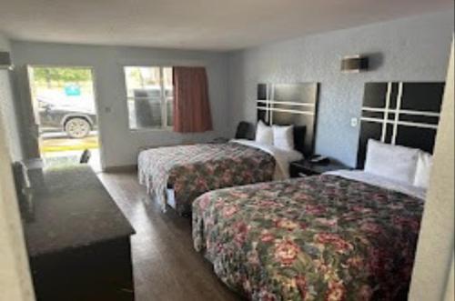 a hotel room with two beds and a table at Relax Inn Hotel in Birmingham