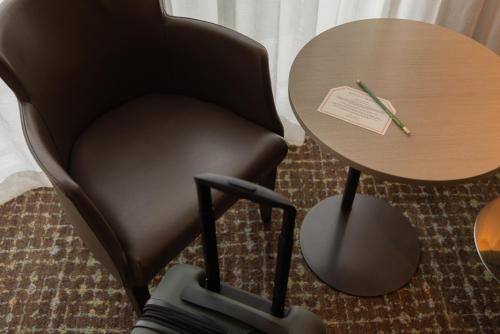 a black chair sitting next to a table with a piece of paper at Point Hotel in Brisbane