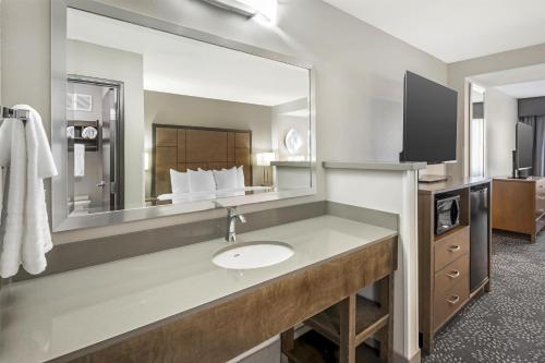 a bathroom with a sink and a large mirror at Best Western Plus Spokane North in Spokane