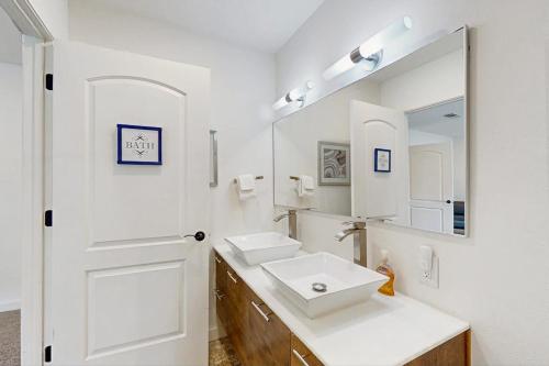 a white bathroom with a sink and a mirror at Waterfront Home with Kayaks, Game Room, Firepit, & Enormous Deck in Kingsland