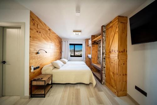 a bedroom with a bed and a flat screen tv at Hostal ZENTRAL in Alora