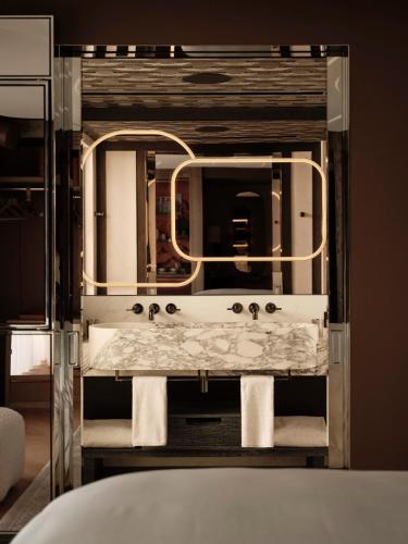 a bathroom with a sink and a large mirror at Rosewood Courchevel Le Jardin Alpin in Courchevel