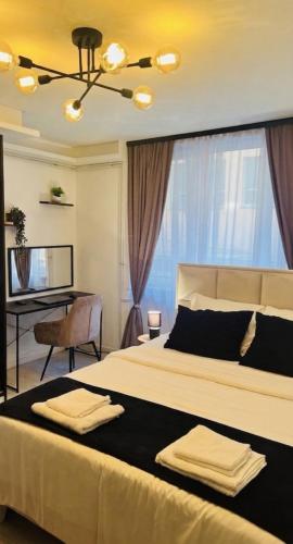 a bedroom with a large bed and a desk at Escapist Apartments in Niš