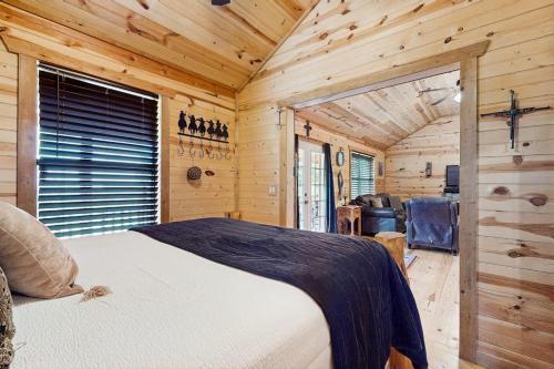 a bedroom with a bed in a wooden cabin at Dog-Friendly Gem on 11 Acres with Valley Views, Deck, Gas Grill, Fireplace in Fredericksburg