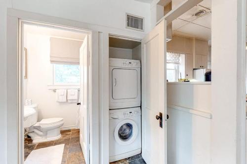 a white laundry room with a washer and dryer at Enchanting Home with Fireplace, Full Kitchen, Patio, Central AC, & Washer/Dryer in Fredericksburg