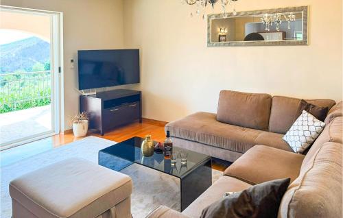 a living room with a couch and a tv at Gorgeous Home In Solin in Solin