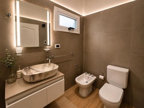 a bathroom with a sink and a toilet at Departamento Parque, Asador y Pileta Privada, uso exclusivo in San Luis