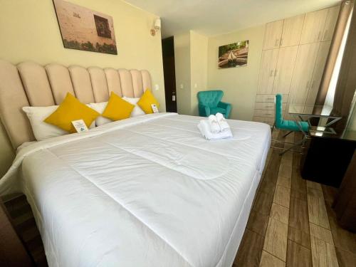 a bedroom with a large white bed with yellow pillows at Bon Repos Boutique in Arequipa