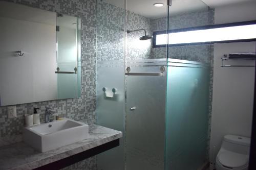 a bathroom with a sink and a glass shower at Departamento de lujo en Col Americana con alberca in Guadalajara