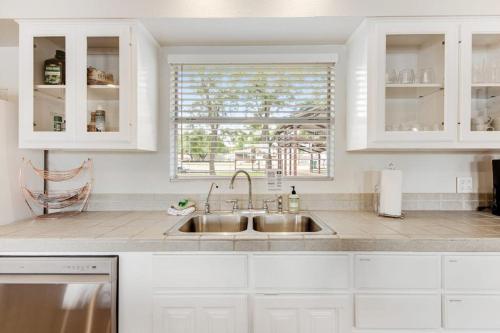 a white kitchen with a sink and a window at Two-Story Waterfront Retreat with Boat Dock, Two Firepits & Two Kayaks in Burnet