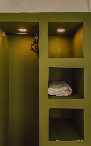 a room with a green door with a towel on it at Hostel Nosara in Playa Guiones