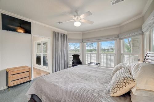 a bedroom with a bed with a ceiling fan and windows at Lakeside, Dog-Friendly Living with Kayaks, Boat Ramp, Pool Table & Ping-Pong in Kingsland