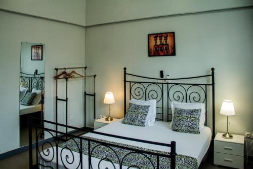a bedroom with a bed with two lamps and two tables at Villa Mélaure in Abomey-Calavi