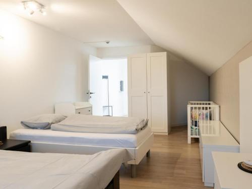 a bedroom with two beds and a closet at De Golfbreker in Middelkerke