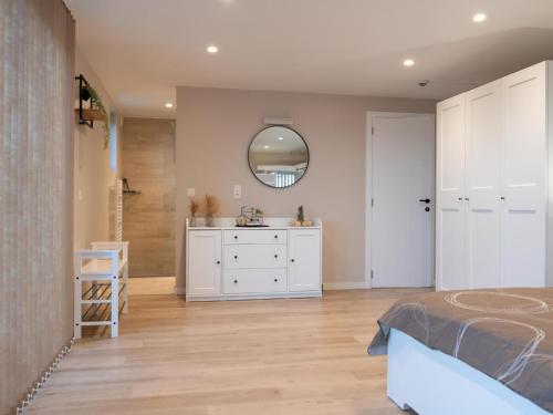a bedroom with a bed and a sink and a mirror at De Golfbreker in Middelkerke