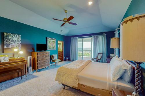 a bedroom with blue walls and a bed and a desk at 2-Story Home with Covered Patio, Balcony, Fireplace, Streaming, Great Views, W/D in Kerrville