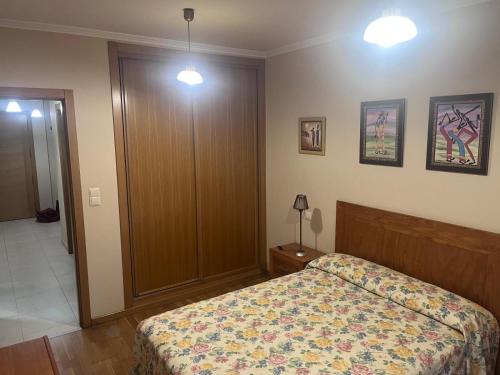 a bedroom with a bed and a wooden door at Piso Salón Paraíso in Bueu