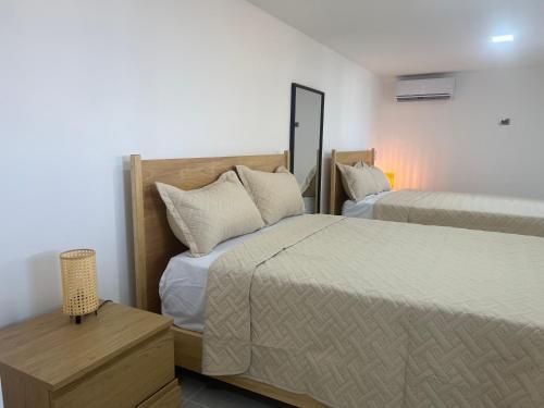 a hotel room with two beds and a night stand at Santa Barbara River house in Santo Domingo