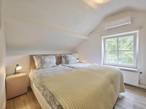 a bedroom with a bed with a yellow bedspread and a window at Spijk vakantiehuis in Spijk