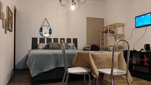 a bedroom with a bed and a table and chairs at Microcasa Pousada Residencial Botânica com Kit Café da manhã in Itupeva