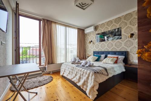 a bedroom with a bed and a large window at 4Season Villa in Tbilisi City
