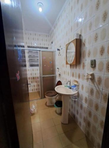 a bathroom with a toilet and a sink and a shower at Pousada Praia Grande in Mongaguá