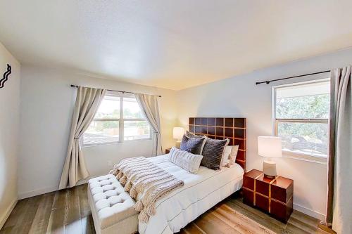 a bedroom with a large bed and two windows at Contemporary, Dog-Friendly Townhouse with Balcony, Pool & Day Docks in Horseshoe Bay