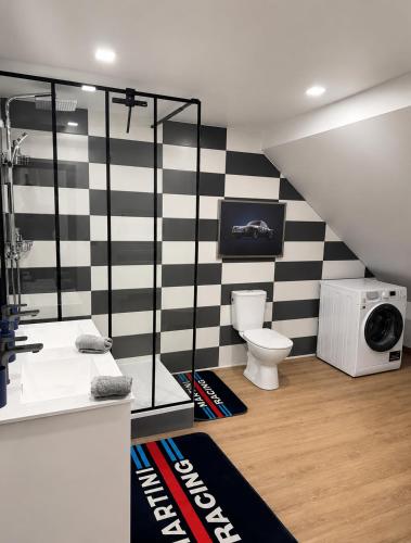 a bathroom with a black and white striped wall at Suite Le Mans 70 in Pusey