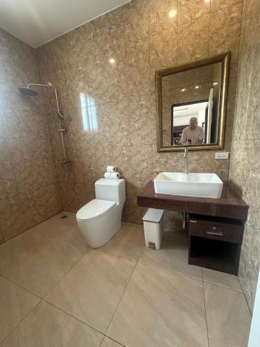 a bathroom with a toilet and a sink and a mirror at AVANA Villa in Nathon Bay