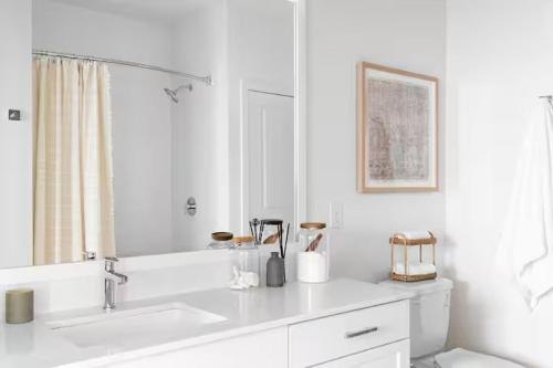a white bathroom with a sink and a mirror at Luxury 1bedroom 1bath Tech Hub in Austin