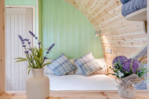 a room with a bed with pillows and a vase with flowers at 1 Bed in Blairdrummond oc-b37875 in Doune