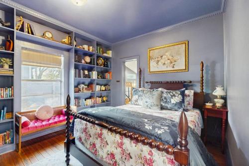 a bedroom with a bed and bookshelves at Blue Haus with Hot Tub, Shuffleboard, EV Charger - Walk to Town & Wineries in Johnson City