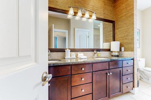 a bathroom with two sinks and a large mirror at Water-View Condo with Balcony, Smart TVs, Washer/Dryer and Pool in Horseshoe Bay