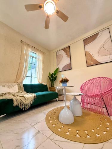 a living room with a green couch and a table at Sakna Mérida con jacuzzi alberca privada in Mérida