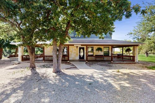 a house with a porch with trees in front of it at Idyllic Home with Firepit, Gazebo, Patio, & Amazing Deck Views - Dog-Friendly in Fredericksburg