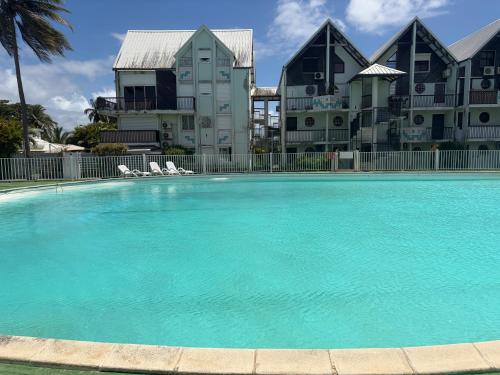 a large swimming pool in front of a building at Pieds dans l eau Piscine Calme Appartement Althéa in Le Gosier