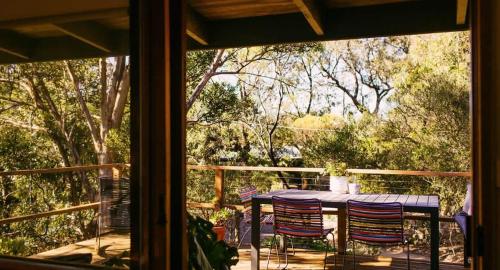 a table and chairs on a porch with a window at A charming escape from everyday life in Aireys Inlet